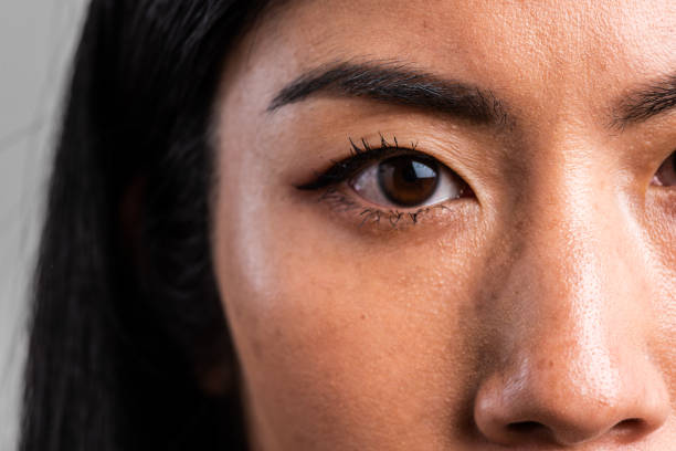 Close up eye of a Serious asian mid adult woman looking at the camera stock photo
