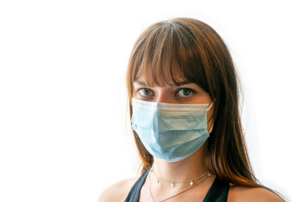 primo piano della giovane donna che indossa una maschera medica con sfondo bianco - patrick zaki foto e immagini stock
