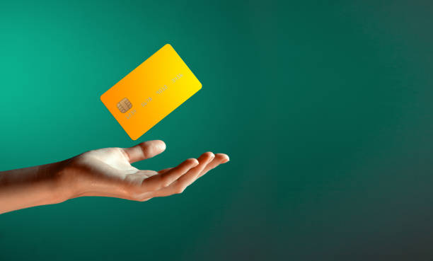 close up female hand holds levitating template mockup bank credit card with online service isolated on green background - credit card imagens e fotografias de stock