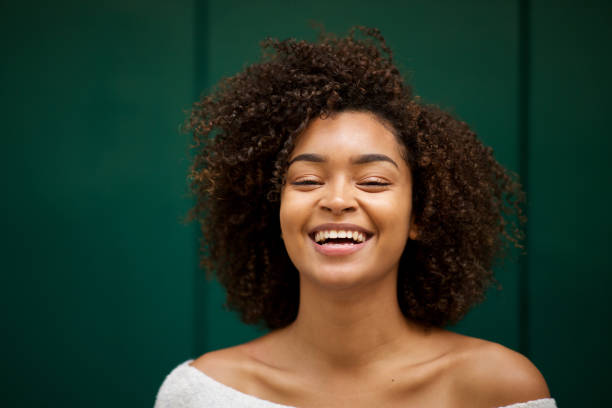 Close up front of young smiling african american woman with curly hair stock photo