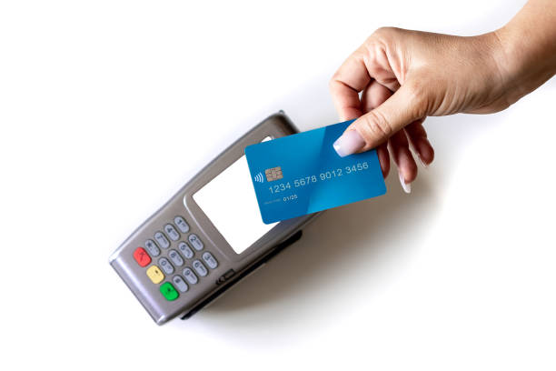 Close up hand of woman paying bill with credit card by contactless woman's hand paying by credit card on a dataphone. Blank dataphone screen. White background. Hand with manicure done. contactless payment stock pictures, royalty-free photos & images