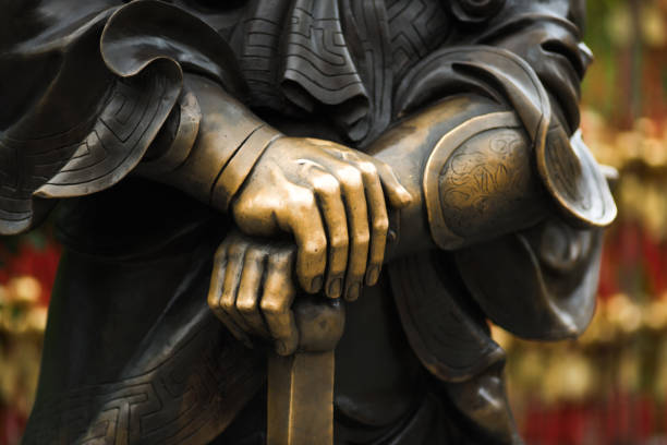 Close up hands and sword of Statue of Chinese General in wong tai sin hands, sword, Chinese, general armour of god stock pictures, royalty-free photos & images