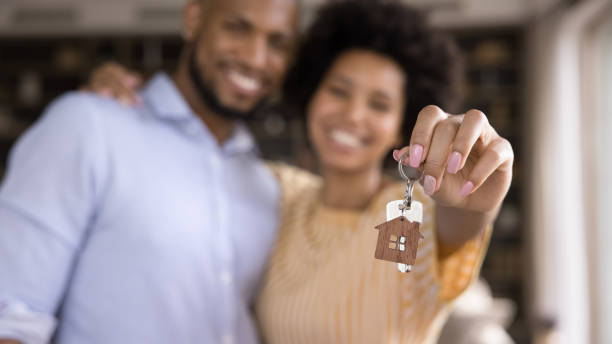 Close up keys in hands of blurred african couple. stock photo