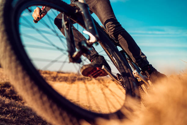 Close up, low angle view of mountain biker on a dusty road stock photo
