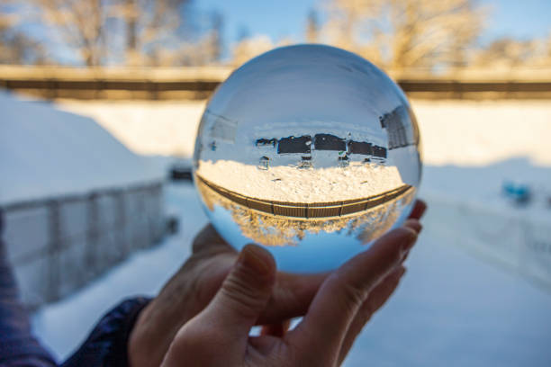 Close up macro view of hand holding crystal ball with inverted  image of winter natural landscape. Sweden. Close up macro view of hand holding crystal ball with inverted  image of winter natural landscape. Sweden. reentry stock pictures, royalty-free photos & images