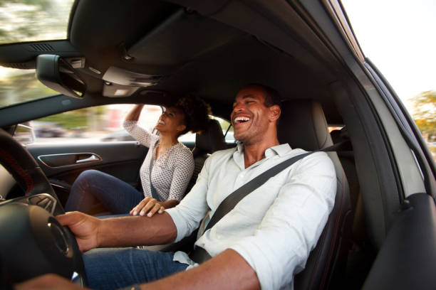 Close up man and woman smiling and sitting together in automobile stock photo