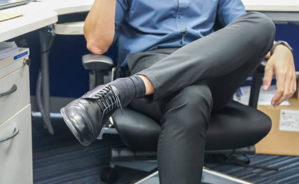 close up men wearing black leather shoes sit and cross his leg on office chair - business man shoes on desk imagens e fotografias de stock