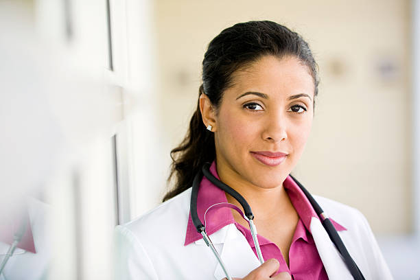 Close up mixed race female doctor with lab coat stethoscope stock photo