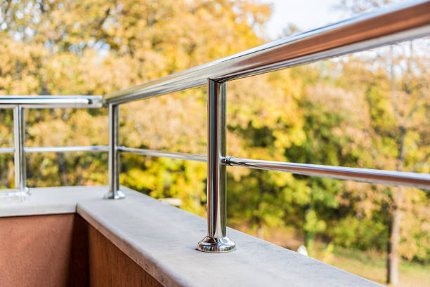 Close up of a balcony metal balustrade. Autumn background. Close up of a balcony metal balustrade. Autumn view in the background. bannister stock pictures, royalty-free photos & images