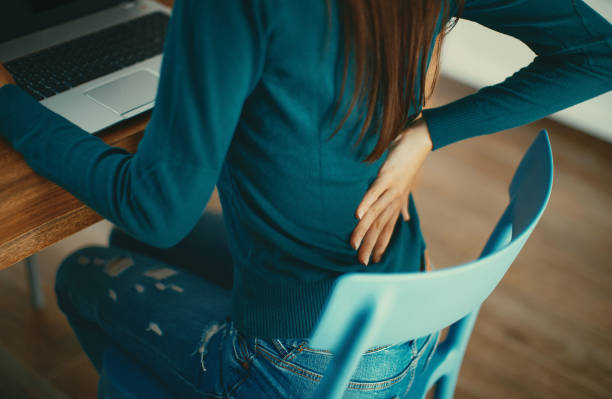 Close up of a brunette woman massaging her back. stock photo