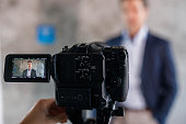 istock Close up of a camera filming male entrepreneur. 1328450354