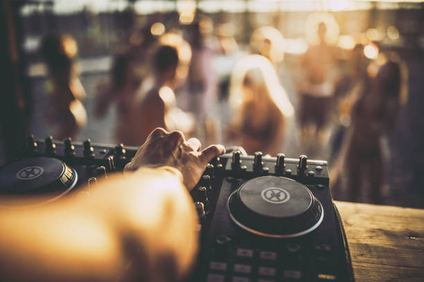 Close up of a DJ playing music on the beach party. Close up of unrecognizable DJ playing music on turntable during summer beach party. dj stock pictures, royalty-free photos & images