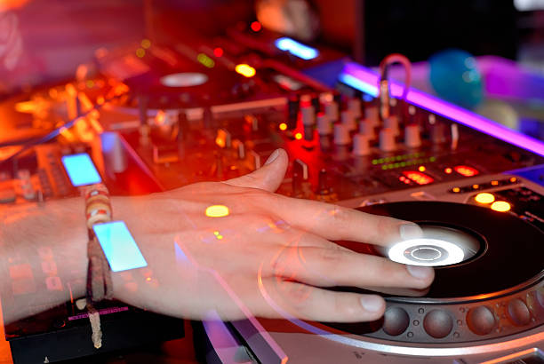 Close up of a DJ's hands, spinning a record on a turntable stock photo