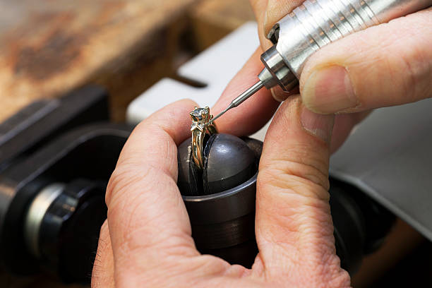 Close up of a jeweler's hands doing a repair A Jeweller is Repairing a Diamond Ring. gold ring on finger stock pictures, royalty-free photos & images