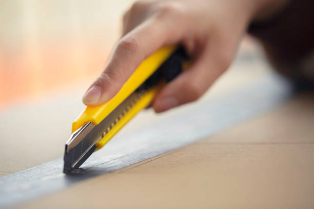 Close up of a person opening a package with a knife stock photo