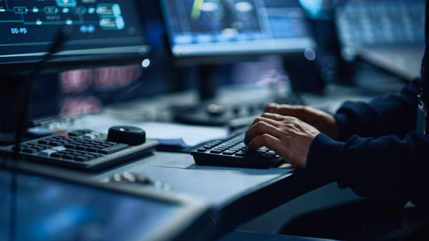 Close Up of a Professional Office Specialist Working on Desktop Computer in Modern Technological Monitoring Control Room with Digital Screens. Manager Typing on keyboard and Using Mouse. stock photo