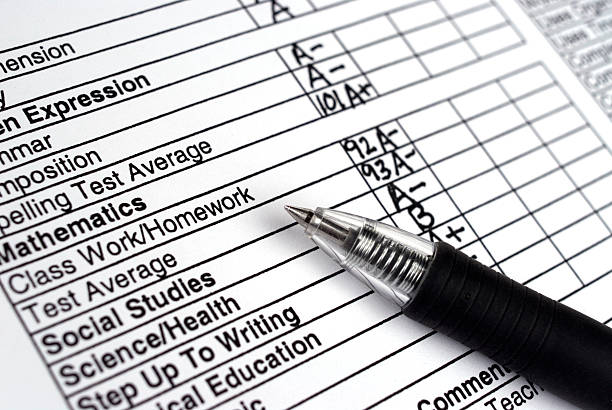 Close up of a report card with a pen Closeup image of childs school progress report. test results stock pictures, royalty-free photos & images