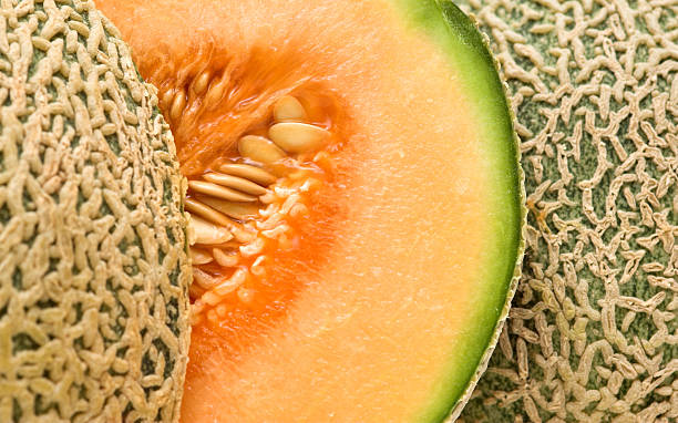 Close up of a ripe cantaloupe melon that is cut in half stock photo