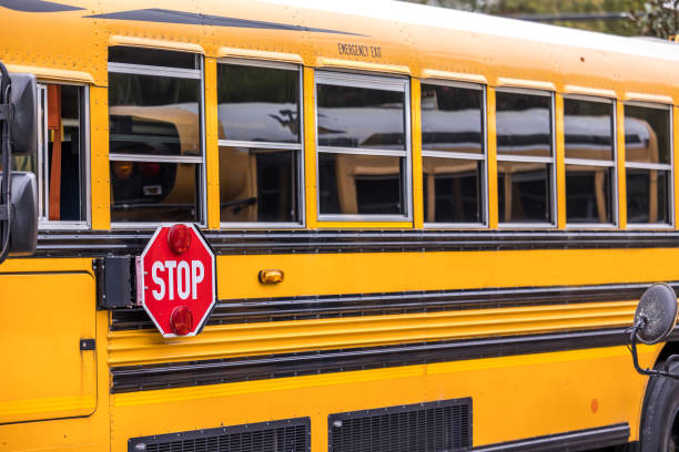 A close up of a yellow orange school bus with a red stop sign for back to school stock photo