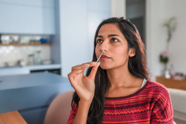 Close Up Of An Indian Young Woman Getting Taking A Covid Self Test In The Kitchen stock photo