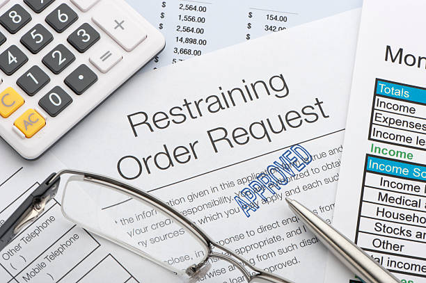 Close up of approved restraining order request Close up of approved restraining order request with pen and calculator restraining stock pictures, royalty-free photos & images