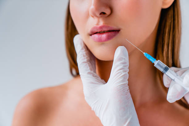 Close up of beautiful woman getiing injection in her lips on background Beauty, Cosmetology, Beautician, Injecting, Women body care and beauty stock pictures, royalty-free photos & images