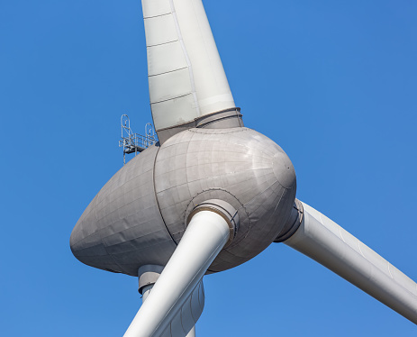 Close up of big wind turbine against a blue sky