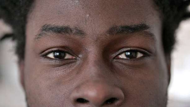 primer plano de los ojos parpadeantes del hombre africano - eye close up fotografías e imágenes de stock