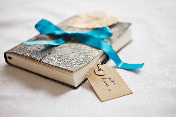 Close up of book tied with ribbon and gift tag  gift book stock pictures, royalty-free photos & images