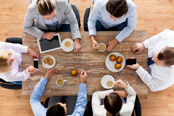 close up of business team drinking coffee on lunch stock photo