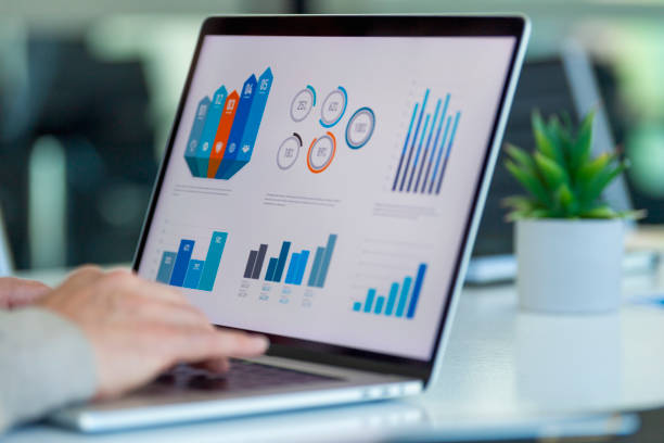 close up of businessman using a laptop with graphs and charts on a laptop computer. - big data imagens e fotografias de stock