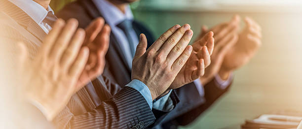 Close up of businessmen in suits clapping stock photo