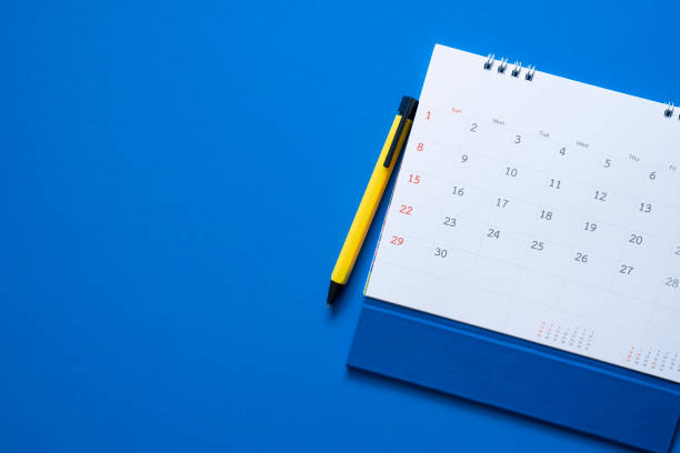 close up of calendar on the blue table background, planning for business meeting or travel planning concept stock photo