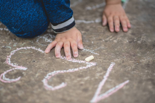 primo tempo di bambini che disegnano numeri con gesso sul marciapiede - kostic foto e immagini stock