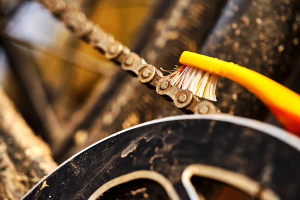 Close up of cleaning a bicycle chain with a toothbrush, care of the bike after winter stock photo