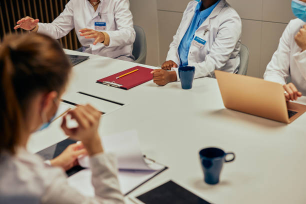Close up of doctors on meeting while sitting at the desk stock photo