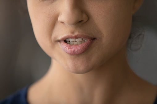 Crop close up of lower face of young Indian woman speak talk. Closeup of millennial mixed race ethnicity female mouth lips, ethnic lady speaker or coach communicate. Diversity, multiracial concept.