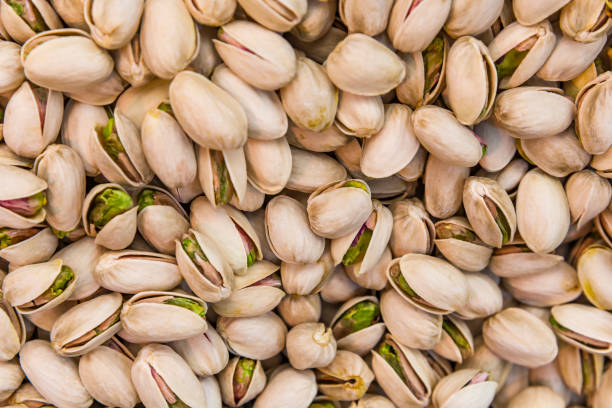 Close up of fresh pistachios. Whole background. Close up of fresh pistachios. Whole background. Pistachio nuts background. pistachio stock pictures, royalty-free photos & images