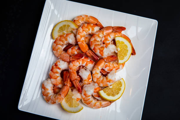 Close up of fresh shrimp on a plate with  lemon slice stock photo