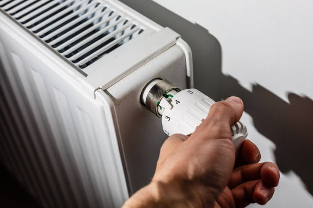 nahaufnahme von hand einstellen heizung thermostat - heizung stock-fotos und bilder