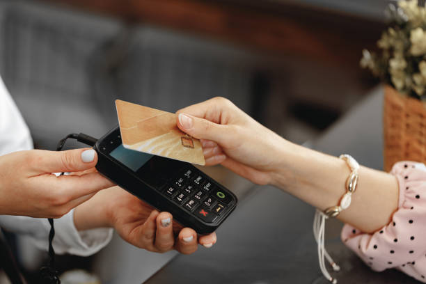 Close up of hand of customer paying with contactless credit card stock photo