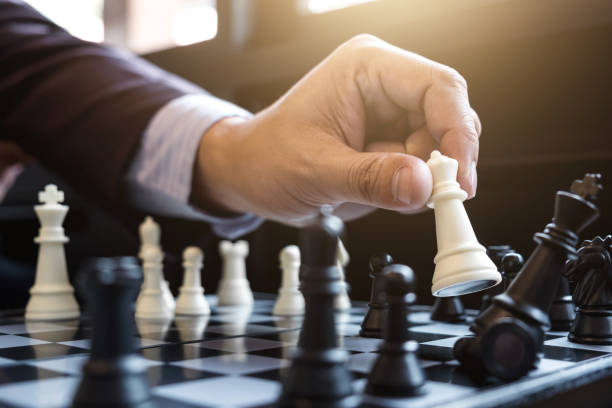 Close up of hands confident businessman colleagues playing chess game to development analysis new strategy plan, leader and teamwork concept for success. stock photo