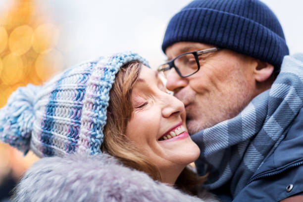 close up of happy senior couple kissing in winter stock photo