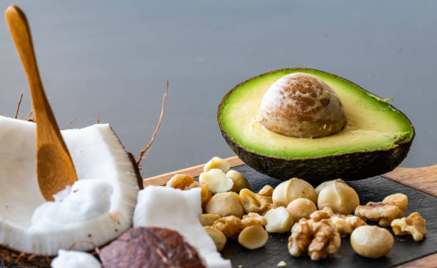 A close up of healthy ketogenic food A close up of ketogenic food: coconut and coconut butter, avocado. walnuts and macadamia nuts fat nutrient stock pictures, royalty-free photos & images