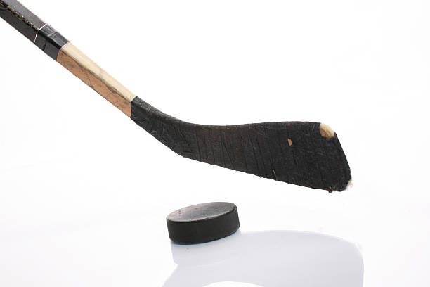 Close up of hockey stick and puck on white background More ice hockey shots - check my lightbox. hockey stick stock pictures, royalty-free photos & images