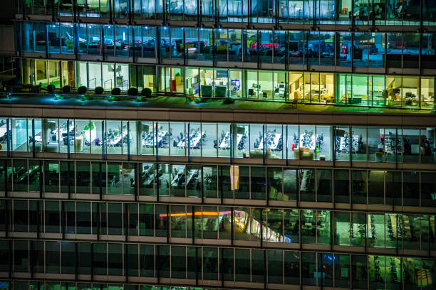 Close up of illuminated modern offices during night hours in London City, UK - creative stock photo stock photo