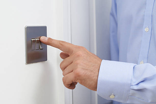Close Up Of Man Turning Off Light Switch Close Up Of Man Turning Off Light Switch light switch stock pictures, royalty-free photos & images