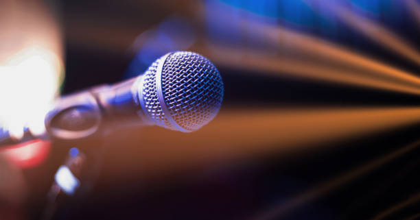 Close up of microphone on stage at night stock photo