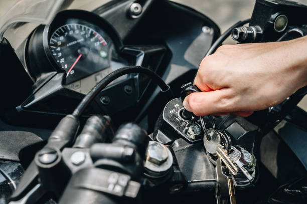 Close up of motorcycle rider hand inserting the key for starting the motorcycle engine. stock photo