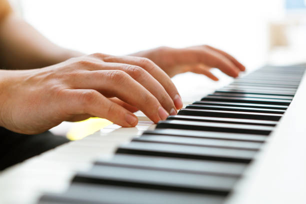 Close up of pianists hand playing piano. Shallow deep of field. stock photo